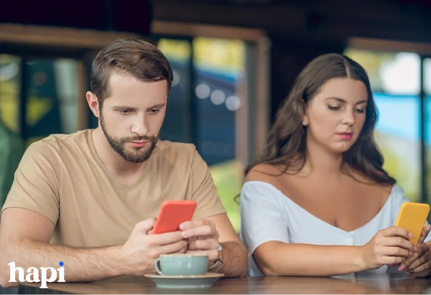 a boy and a girl checking their phones