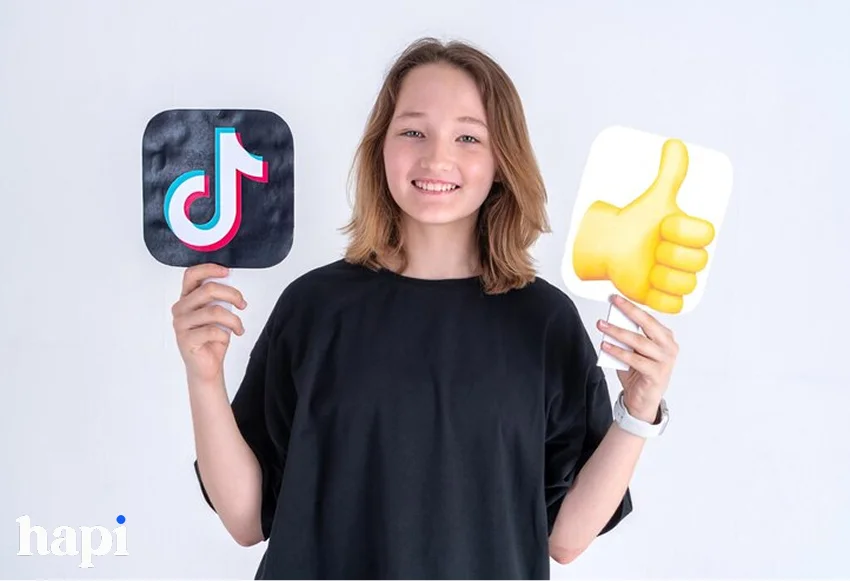 a girl holding TikTok sign