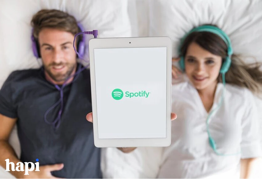a man and woman sleeping in bed listening to music