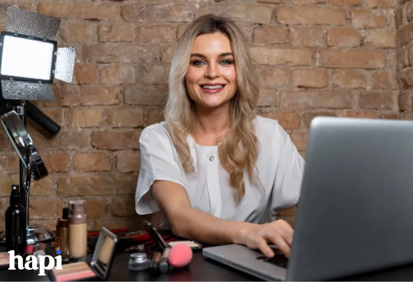 a blond woman sitting behind a desk working on a computer