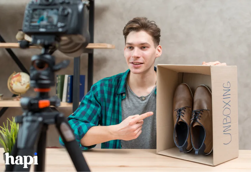 a man showcasing a pair of shoes in front of a camera