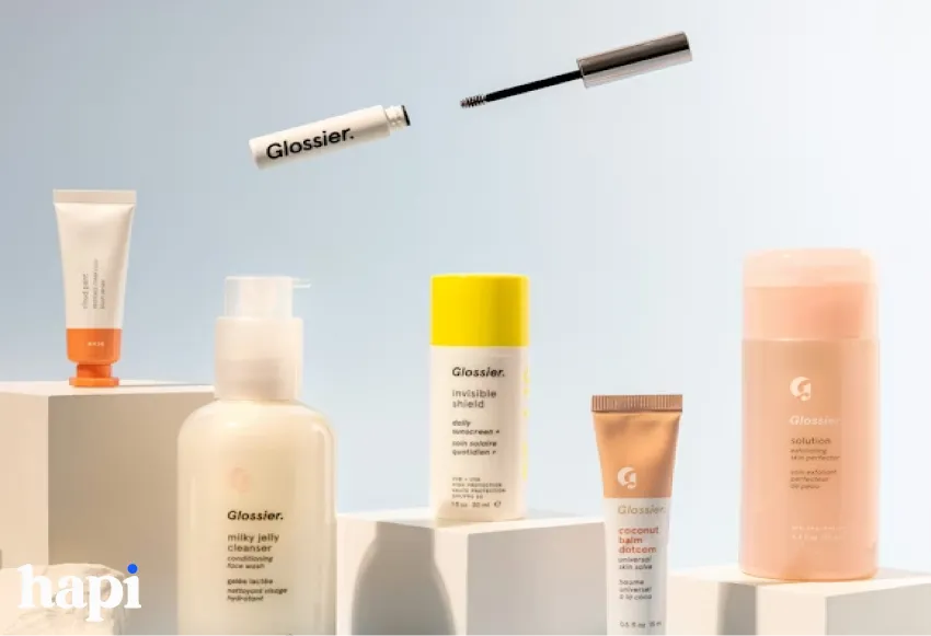 a few different Glossier products on a blue background