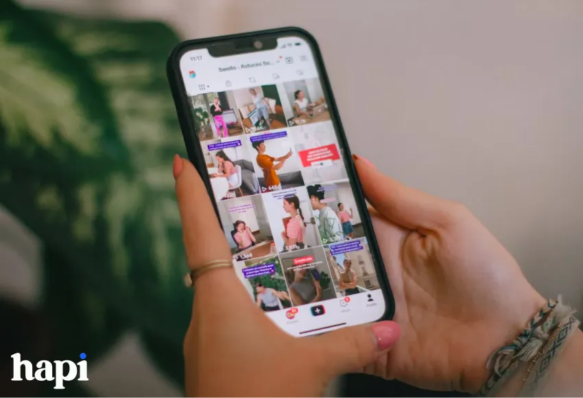 a woman holding a phone with TikTok on the screen