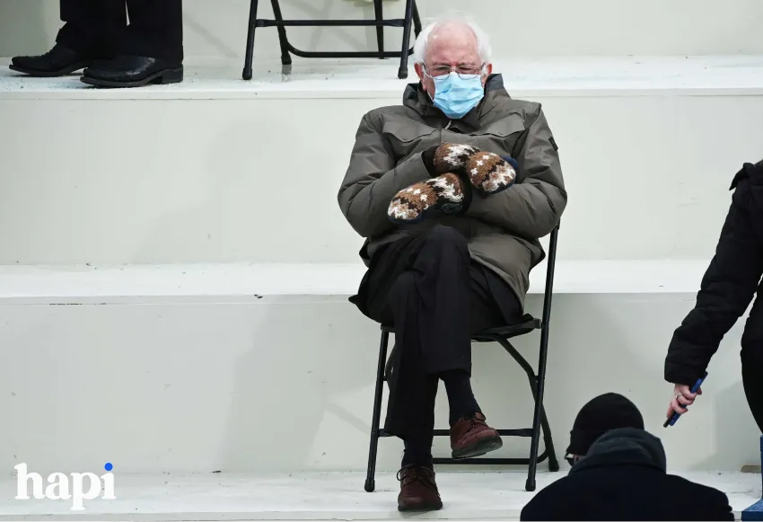 Bernie Sanders sitting on a chair wearing gloves and mask with his famous winter coat